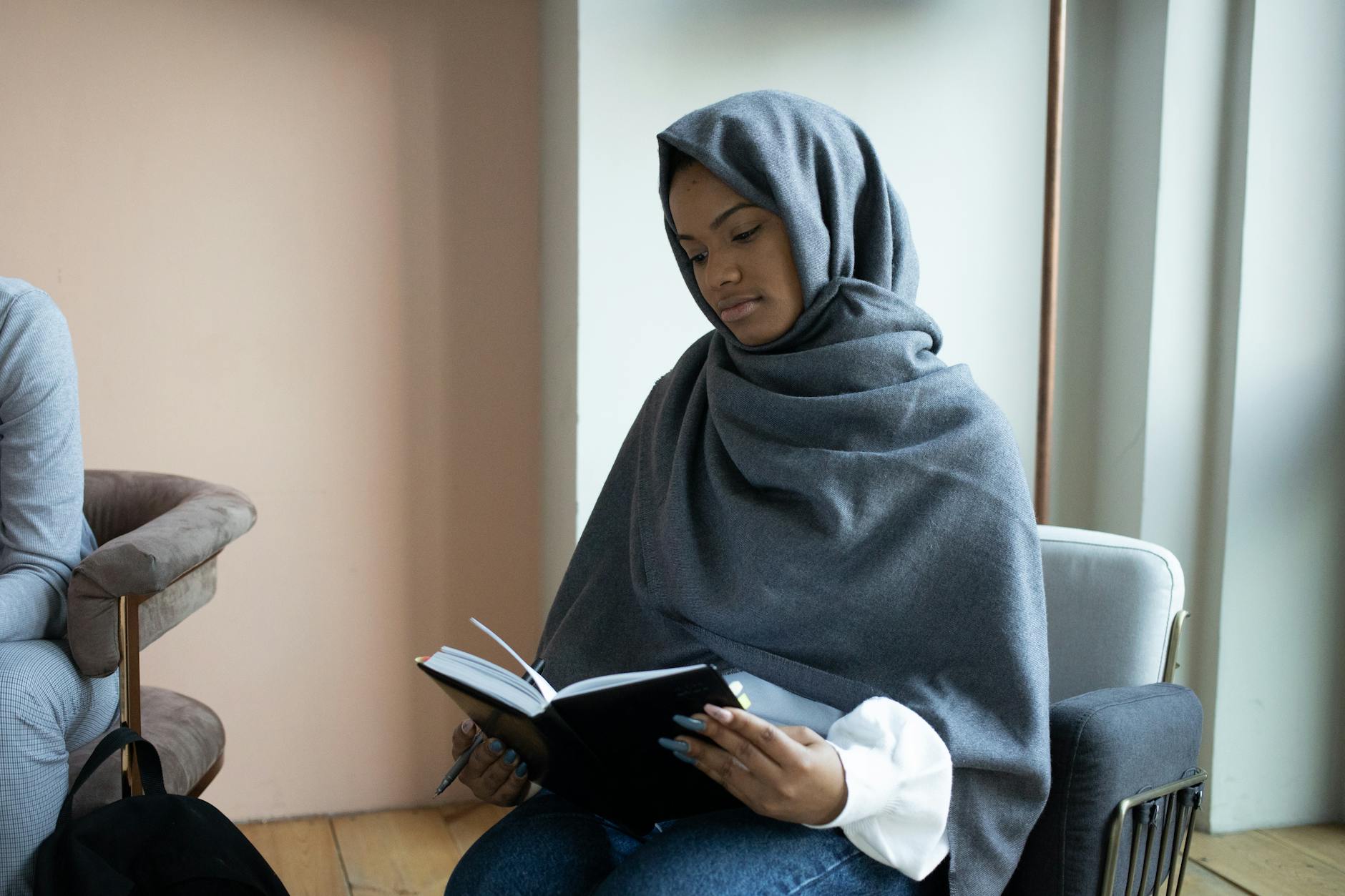 focused muslim woman reading book in studio