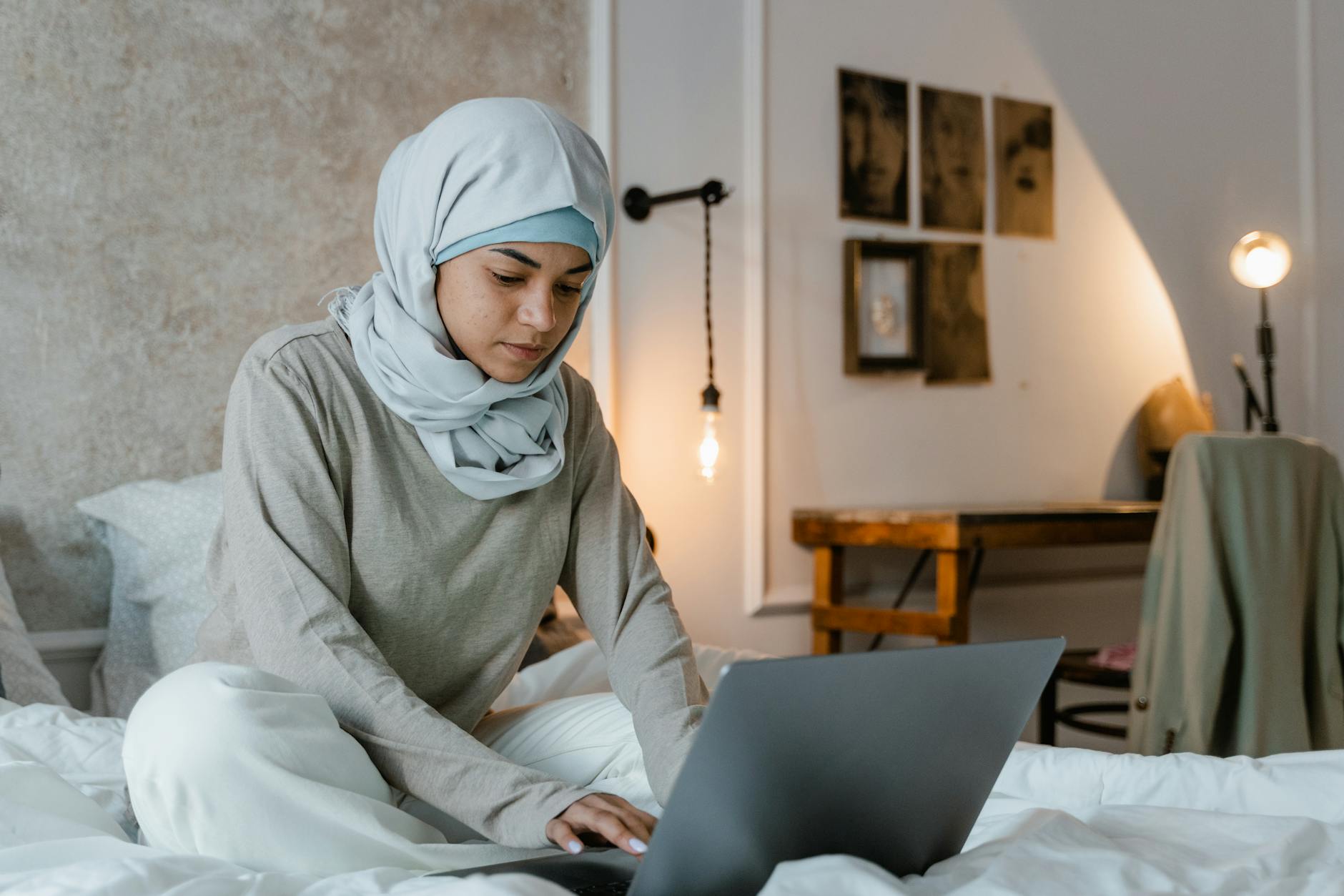 a woman in gray hijab using laptop